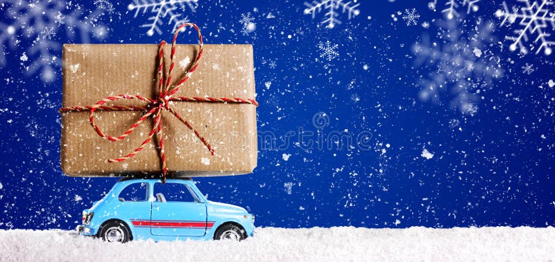 Retro toy car delivering Christmas or New Year gifts on festive blue background. Retro toy car delivering Christmas or New Year gifts on festive blue background