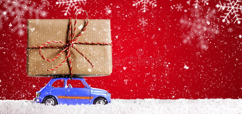 Blue retro toy car delivering Christmas or New Year gifts on festive red background. Blue retro toy car delivering Christmas or New Year gifts on festive red background