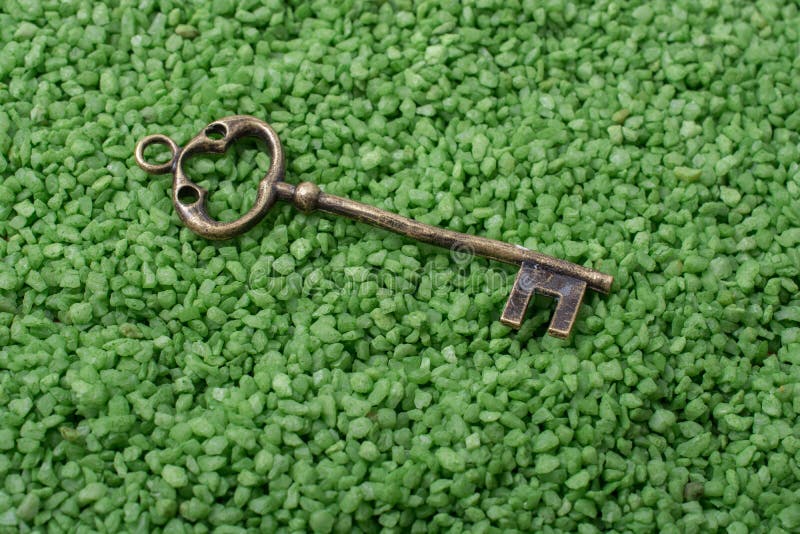 Retro style key on green sand royalty free stock photo Retro style key on green sand royalty free stock photo