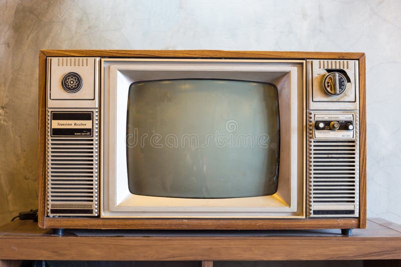 Retro tv with wooden case in room with vintage wallpaper on wood table