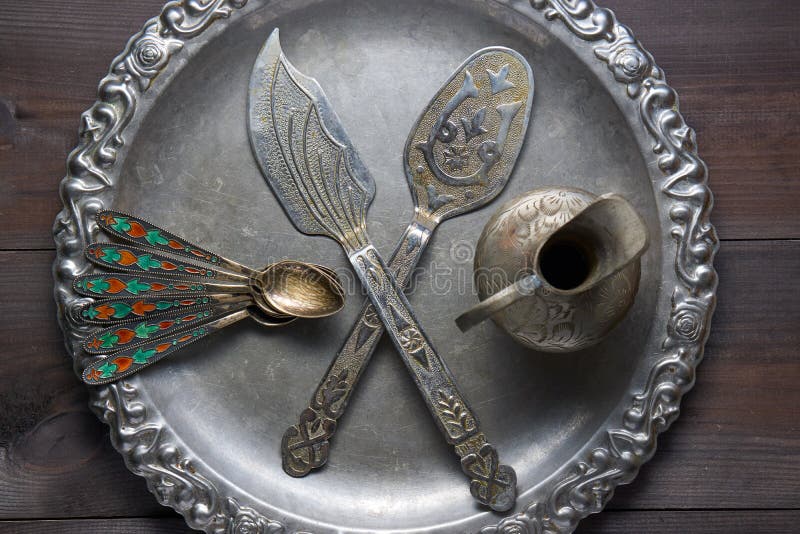 Retro utensile d'argento della cucina con gli ornamenti sul vassoio d'argento fotografia stock libera da diritti Retro utensile d'argento della cucina con gli ornamenti sul vassoio d'argento fotografia stock libera da diritti