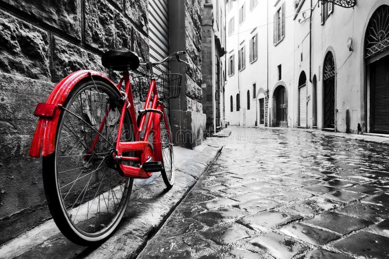 Retro vintage red bike on cobblestone street in the old town. Color in black and white stock photo