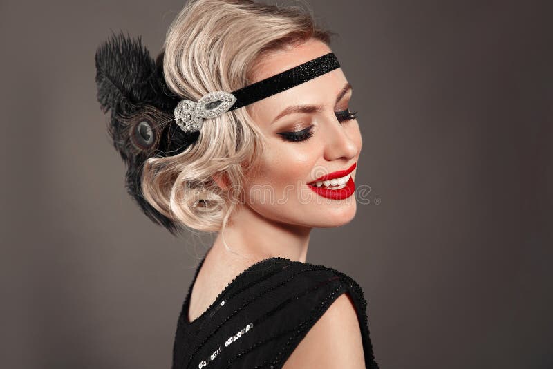 Retro woman portrait. Blonde wavy hairstyle. Hollywood red lips makeup. Curly hair style. Beautiful elegant female wears in vintage dress isolated on dark studio background