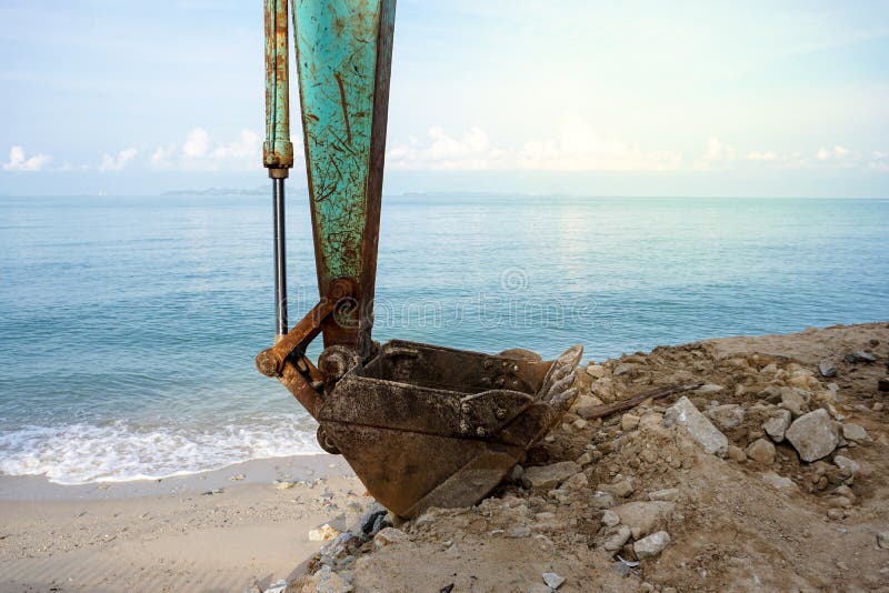 Backhoe on the beach doing constructions. Backhoe on the beach doing constructions.