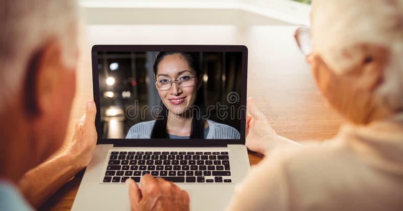 Retrovisione delle coppie senior che hanno videoconferenza con la donna sul computer portatile fotografia stock libera da diritti Retrovisione delle coppie senior che hanno videoconferenza con la donna sul computer portatile fotografia stock libera da diritti