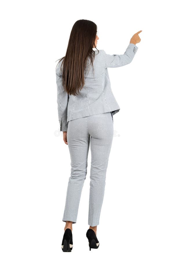 Retrovisione di giovane donna di affari in vestito che indica la destra immagini stock Retrovisione di giovane donna di affari in vestito che indica la destra immagini stock