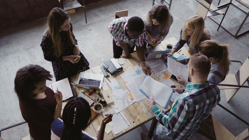 Reunião de negócios no escritório moderno Ideia superior do grupo de pessoas multirracial que trabalha perto da tabela junto fotos de stock Reunião de negócios no escritório moderno Ideia superior do grupo de pessoas multirracial que trabalha perto da tabela junto fotos de stock