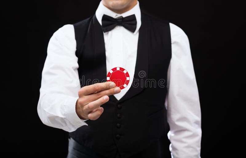 Revendeur tenant le jeton de poker rouge photos libres de droits Revendeur tenant le jeton de poker rouge photos libres de droits