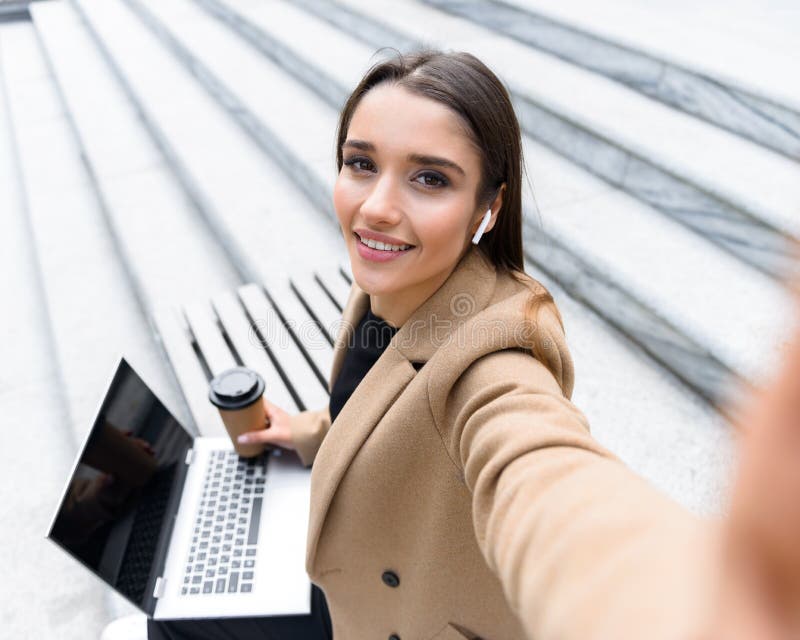 Revestimento vestindo do outono da jovem mulher bonita usando o portátil imagens de stock Revestimento vestindo do outono da jovem mulher bonita usando o portátil imagens de stock