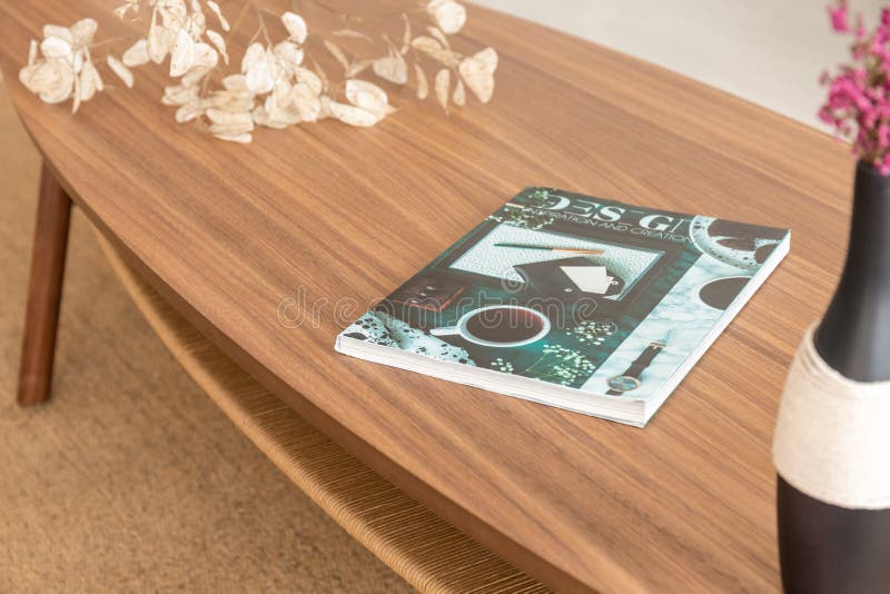 Revista colorida en la tabla de madera en sala de estar elegante del apartamento moderno imágenes de archivo libres de regalías Revista colorida en la tabla de madera en sala de estar elegante del apartamento moderno imágenes de archivo libres de regalías