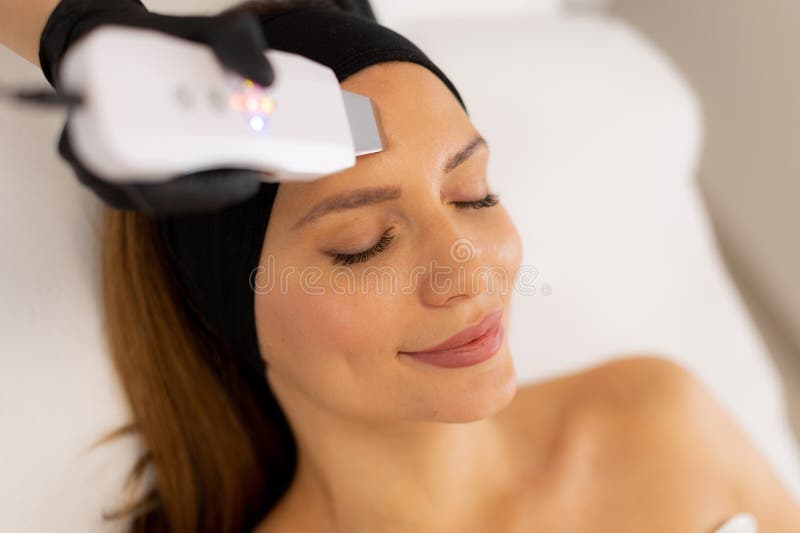 Soothing vibrations from the ultrasonic facial massager create a rejuvenating experience as the expert skincare professional cleanses and revitalizes the client’s radiant complexion. Pampering experience stock images, royalty-free photos and pictures