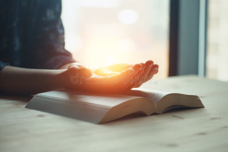 Rezando manos jóvenes rezando con las manos juntas sobre un santo espiritual de la biblia fotografía de archivo libre de regalías