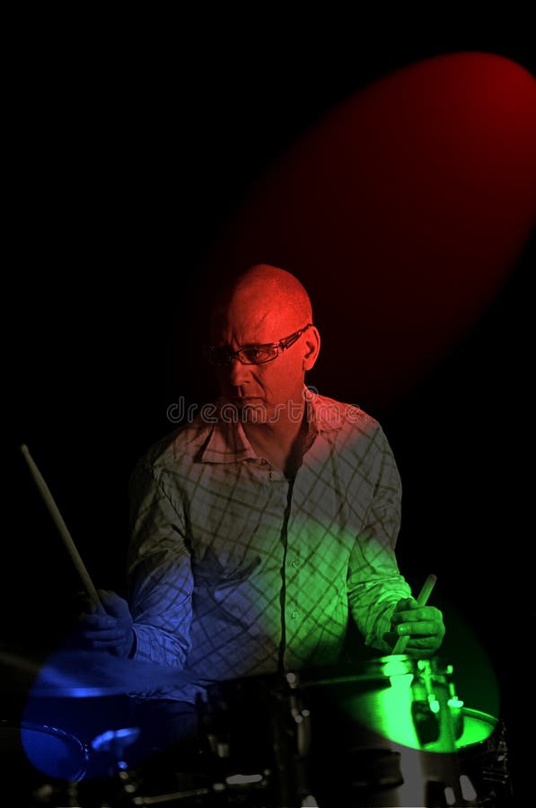 Drummer playing over black backdrop with rgb lighting
