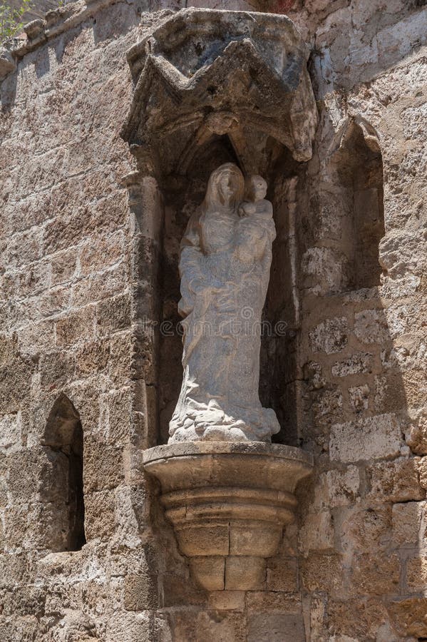 Rhodes Grekland Maj 30, 2018 Gatan av riddarna Staty av jungfruliga Mary med barnet Kyrka av St-Treenighet och departement av royaltyfri bild Rhodes Grekland Maj 30, 2018 Gatan av riddarna Staty av jungfruliga Mary med barnet Kyrka av St-Treenighet och departement av royaltyfri bild