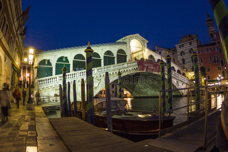 VENICE, ITALY - APRIL 11, 2007: Rialto Bridge, Grand Canal, unidentified people watch the rialto bridge by night in Venice, Italy. Canale Grande is 3,800 m long, 30â€“90 m wide, with an average depth of five meters. VENICE, ITALY - APRIL 11, 2007: Rialto Bridge, Grand Canal, unidentified people watch the rialto bridge by night in Venice, Italy. Canale Grande is 3,800 m long, 30â€“90 m wide, with an average depth of five meters.