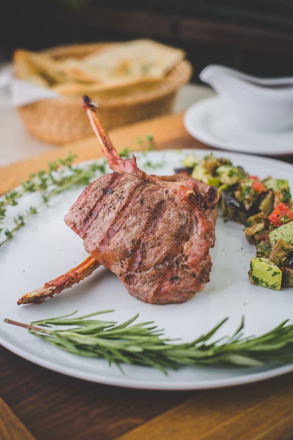 Rib steak on a white plate with ratatouille. Steak(entrecote, rib-eye, Rib steak, Scotch fillet ) on a white plate with vegetable ratatouille royalty free stock photography Rib steak on a white plate with ratatouille. Steak(entrecote, rib-eye, Rib steak, Scotch fillet ) on a white plate with vegetable ratatouille royalty free stock photography