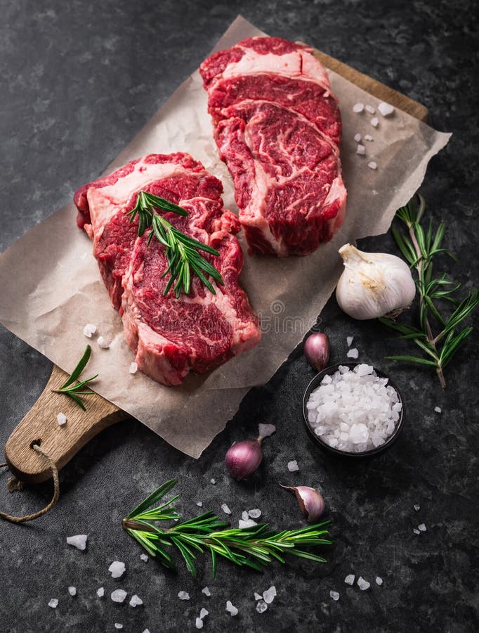 Ribeye marbré frais cru de bifteck d'Angus de noir de la viande deux, ail, sel image stock