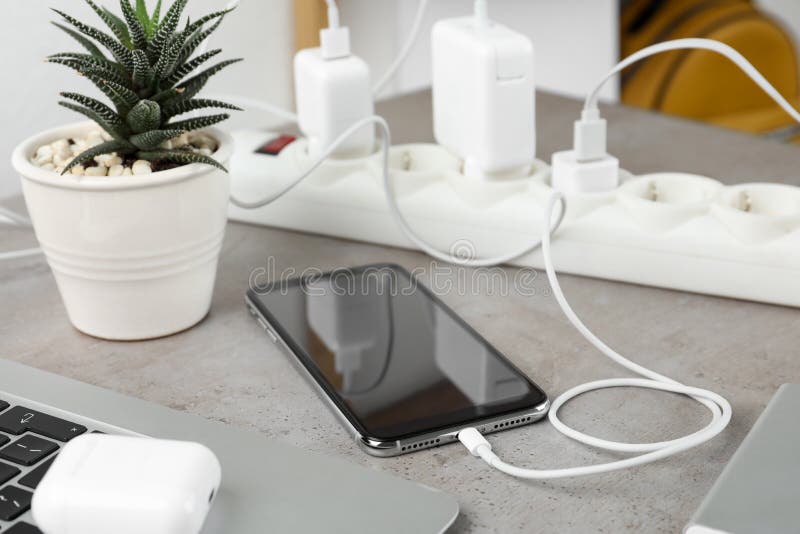 Ricarica di smartphone con cavo su tavolo a pietra