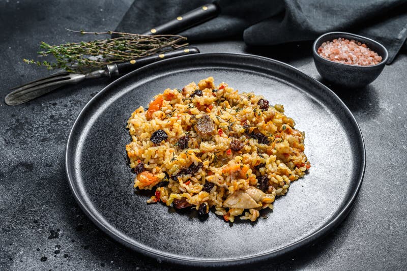 Rice Pilaf with Lamb Meat and Vegetables in a Plate. Black Background