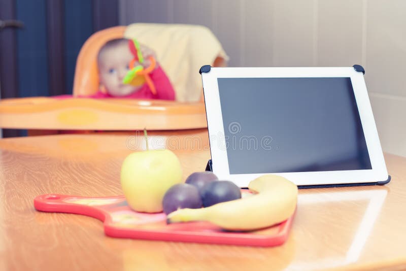 Ricerca della ricetta degli alimenti per bambini della preparazione al pc della compressa fotografia stock Ricerca della ricetta degli alimenti per bambini della preparazione al pc della compressa fotografia stock