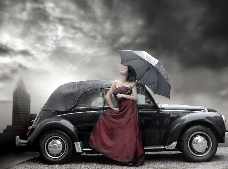 Lady in purple dress and holding umbrella next to vintage luxury car. Lady in purple dress and holding umbrella next to vintage luxury car
