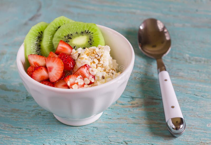 Ricotta con le fragole, kiwi, miele, cereali e semi di lino - un alimento sano, prima colazione saporita e sana o spuntino fotografia stock libera da diritti