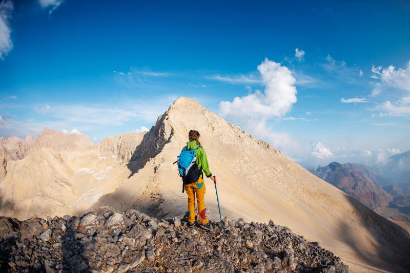 Ricreazione attiva in natura. alpinismo e arrampicata. In montagna. Una ragazza con uno zaino cammina lungo una strada fotografia stock libera da diritti