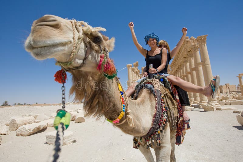 Due ragazze sono in giro sul cammello nel deserto.