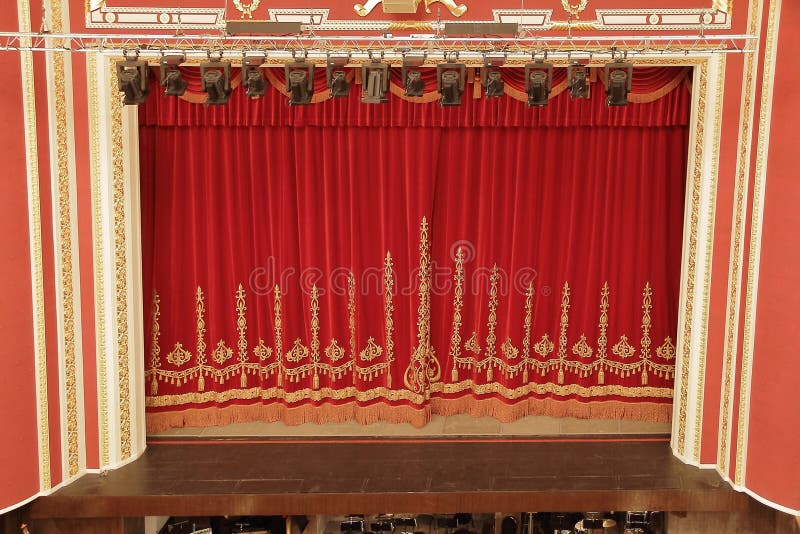 Theatrical red velvet curtain with gold pattern. Theatrical red velvet curtain with gold pattern