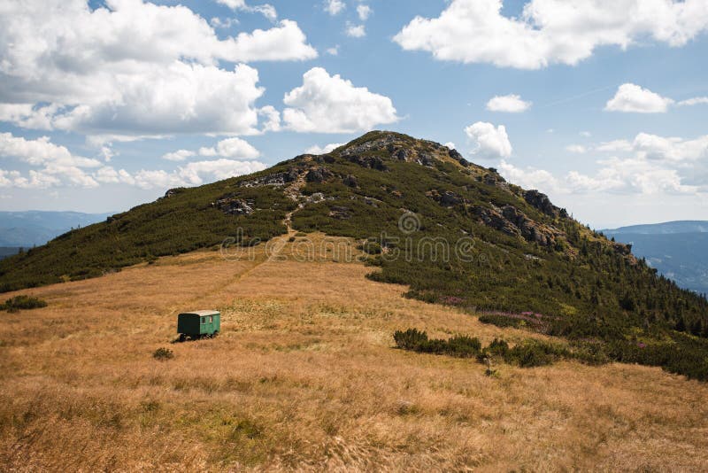 Hřeben hory a suchá louka se zelenou karavanou pod kopcem. Fotografie krajiny z kopce v národním parku na Slovensku