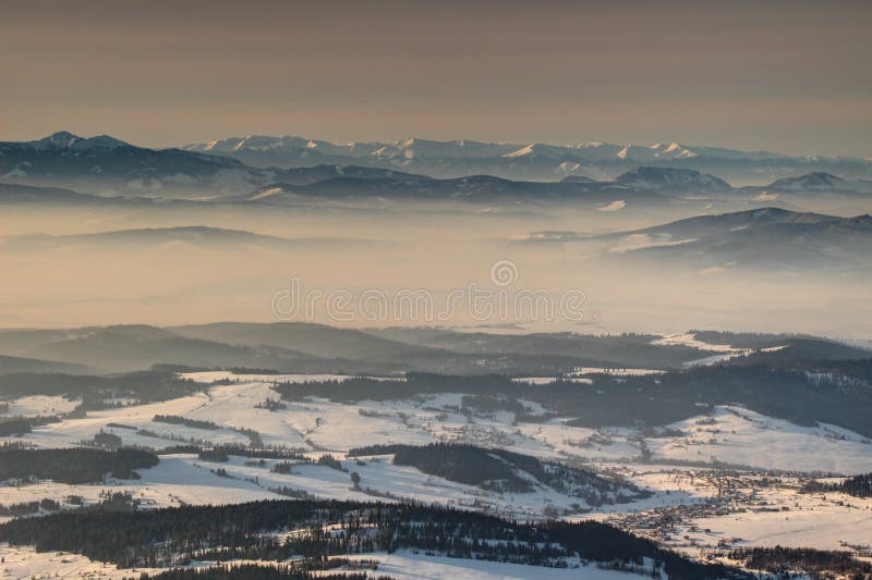 Hřebeny a údolí v mlze v zářícím ranním světle Slovensko