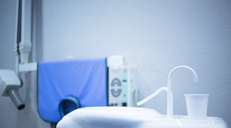 Riempitore del rubinetto della tazza della risciacquatura con acqua del dentista nei dentisti dentari della clinica