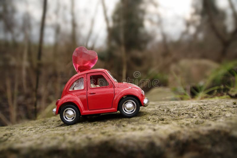 Rieps, Duitsland - Februari 1, 2018: rode miniatuurauto met een hart op de dakaandrijving door een rots