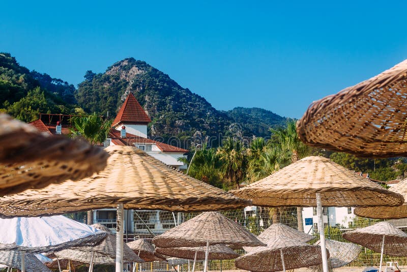 Rieten grote paraplu's op sunbeds op het strand van het hotel royalty-vrije stock afbeeldingen Rieten grote paraplu's op sunbeds op het strand van het hotel royalty-vrije stock afbeeldingen