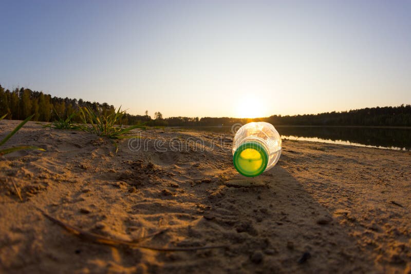 Rifiuti sulla spiaggia, sulla bottiglia di plastica sulla sabbia con il mare e sull'onda immagini stock libere da diritti Rifiuti sulla spiaggia, sulla bottiglia di plastica sulla sabbia con il mare e sull'onda immagini stock libere da diritti