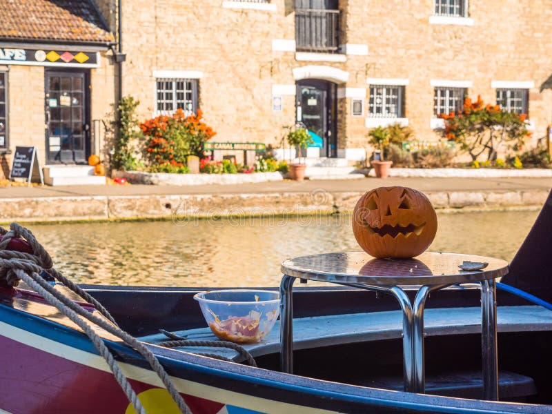 Rifornisca Bruerne il Regno Unito il 31 ottobre 2018: Halloween scolpito che pumpking sulla tavola fuori della barca di fiume del fotografia stock Rifornisca Bruerne il Regno Unito il 31 ottobre 2018: Halloween scolpito che pumpking sulla tavola fuori della barca di fiume del fotografia stock