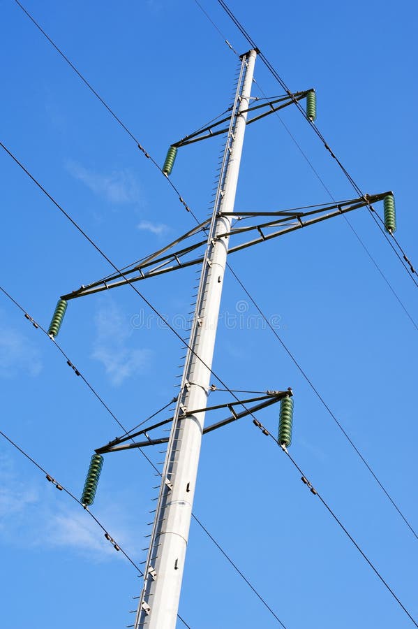 High-voltage transmission line tower on blue sky background. High-voltage transmission line tower on blue sky background