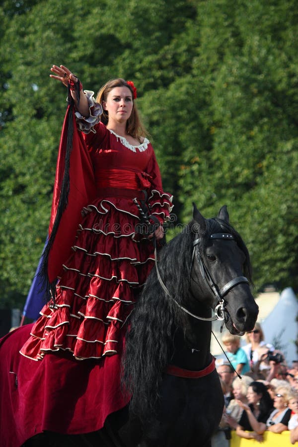 RIGA, LATVIA - AUGUST 21: Camilla Naprous from The Devils Horsemen stunt team riding beautiful black horse during Riga Festival o