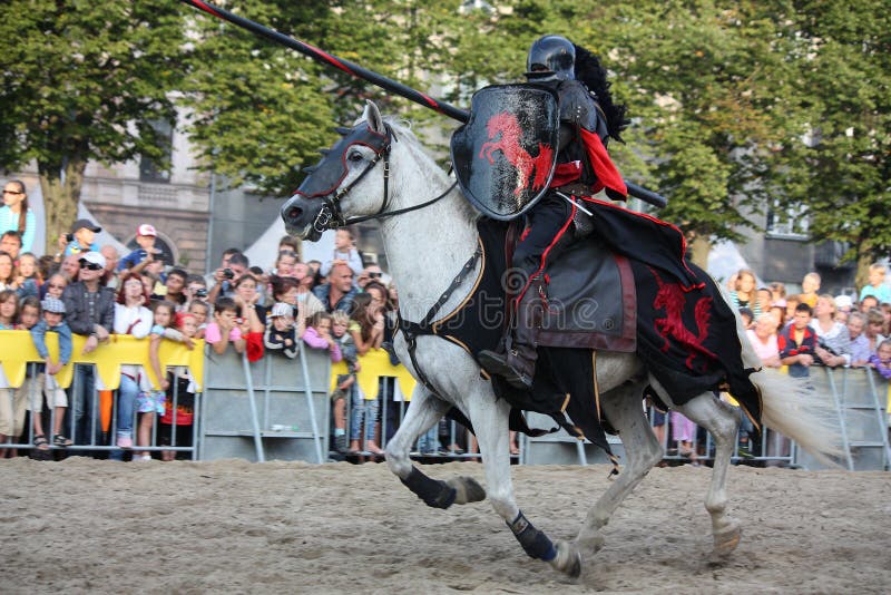 RIGA, LATVIA - AUGUST 21: Gerard Naprous from The Devils Horsemen stunt team riding white horse during Riga Festival on August