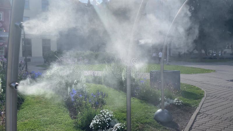 Riga latvia 5 juillet 2024 : système de refroidissement à la brume d'eau dans la rue en une journée chaude. jets d'eau brouillard banque de vidéos