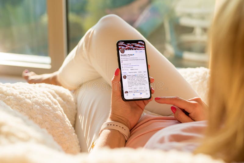 Riga, Latvia - July 21, 2018: Woman reading tweets of Donald Trump on Twitter.