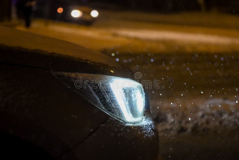 Car light during snowfall editorial photography. Image of forecast