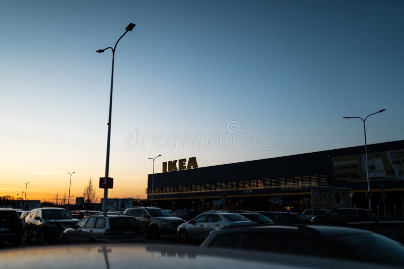RIGA, LETONIA - 3 DE ABRIL DE 2019: Muestra de la marca de IKEA durante la tarde oscura y viento - cielo azul en el fondo fotos de archivo libres de regalías RIGA, LETONIA - 3 DE ABRIL DE 2019: Muestra de la marca de IKEA durante la tarde oscura y viento - cielo azul en el fondo fotos de archivo libres de regalías