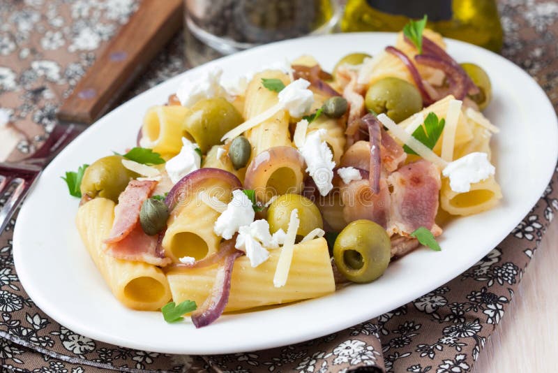 Rigatoni pasta med bacon, gröna oliv, fetaost, röd lök