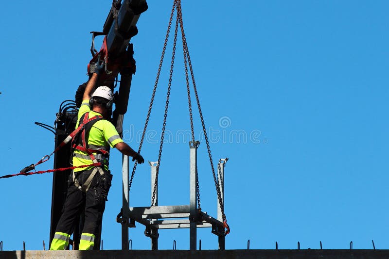 Rigger helpt kraan, die rigth saldo en richting houden stock afbeelding Rigger helpt kraan, die rigth saldo en richting houden stock afbeelding