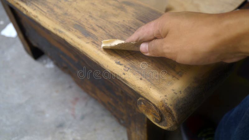 Right hand using sandpaper for wood restauration