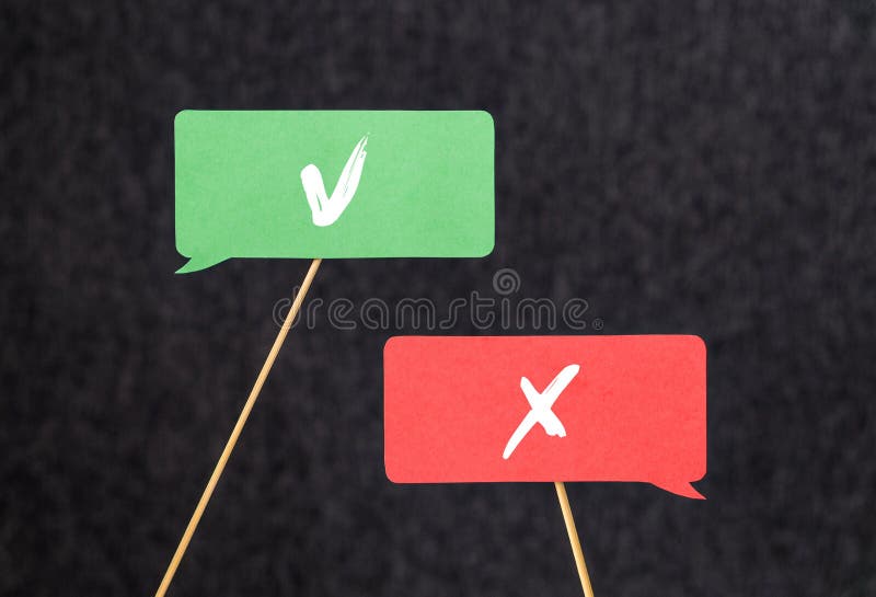 Right and wrong. Disagreement, argument and fight concept. Different opinions, morals and values. V and X sign on cardboard speech bubbles and chat balloons on wooden stick.