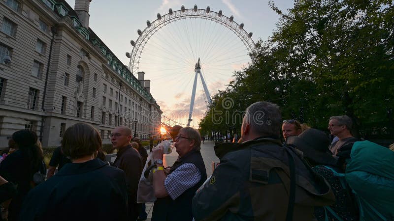 Rij om de koningin te zien die in de staat ligt gestopt voor het london oog bij zonsondergang