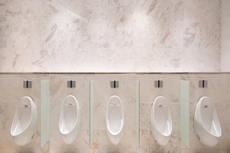 Rij van vijf urinoirs met infrarode sensor, op marmeren muur, in het openbare toilet van mensen stock foto's Rij van vijf urinoirs met infrarode sensor, op marmeren muur, in het openbare toilet van mensen stock foto's