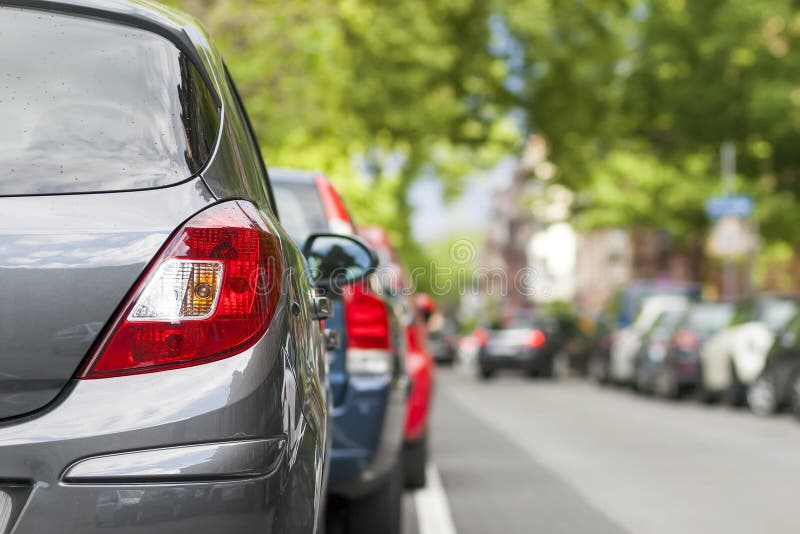 Rijen van auto's op de kant van de weg in woondistrict worden geparkeerd dat stock afbeeldingen Rijen van auto's op de kant van de weg in woondistrict worden geparkeerd dat stock afbeeldingen